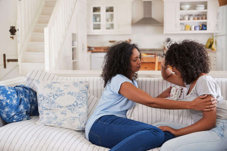 A young black woman is comforted by a relative after having a discussion about ADHD A young black woman is comforted by a relative after having a discussion about ADHD