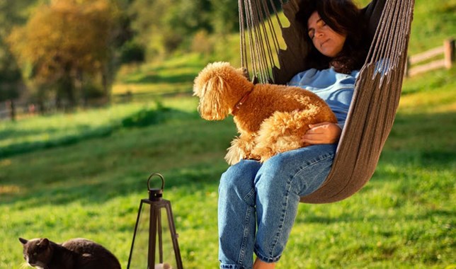 Woman in hammock chair interacting with her pets for a natural mood-boost