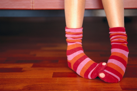 Woman wearing colorful striped socks with holes