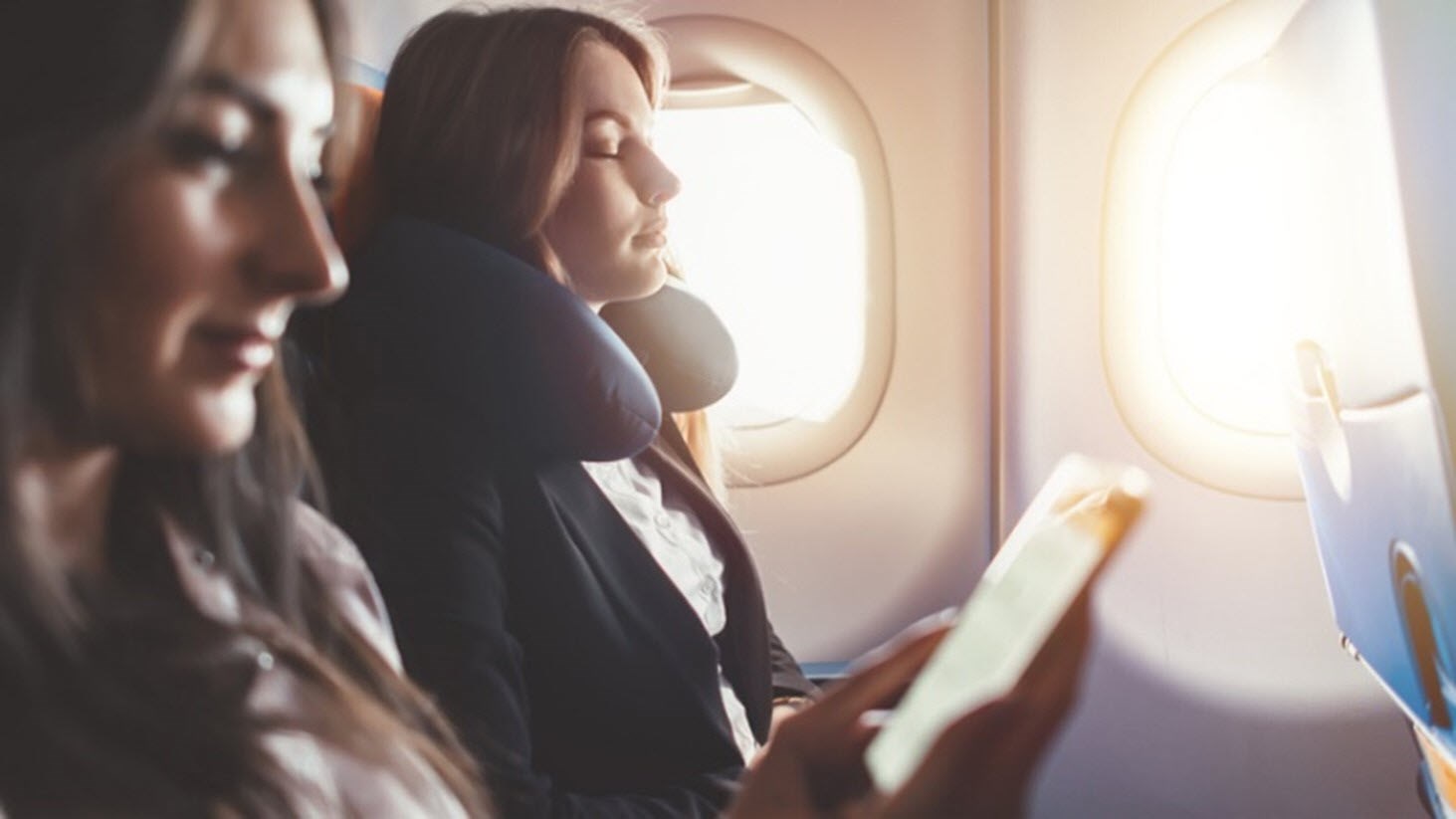 Young woman on plane using meditation techniques to combat anxiety.