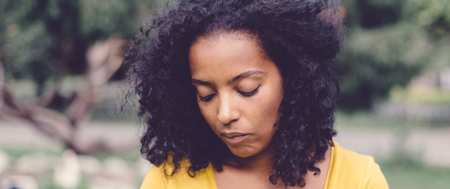 Woman averting her eyes and looking unhappy as she deals with depression