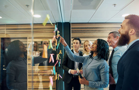 A smiling black woman with ADHD presents information to her colleagues during a meeting.